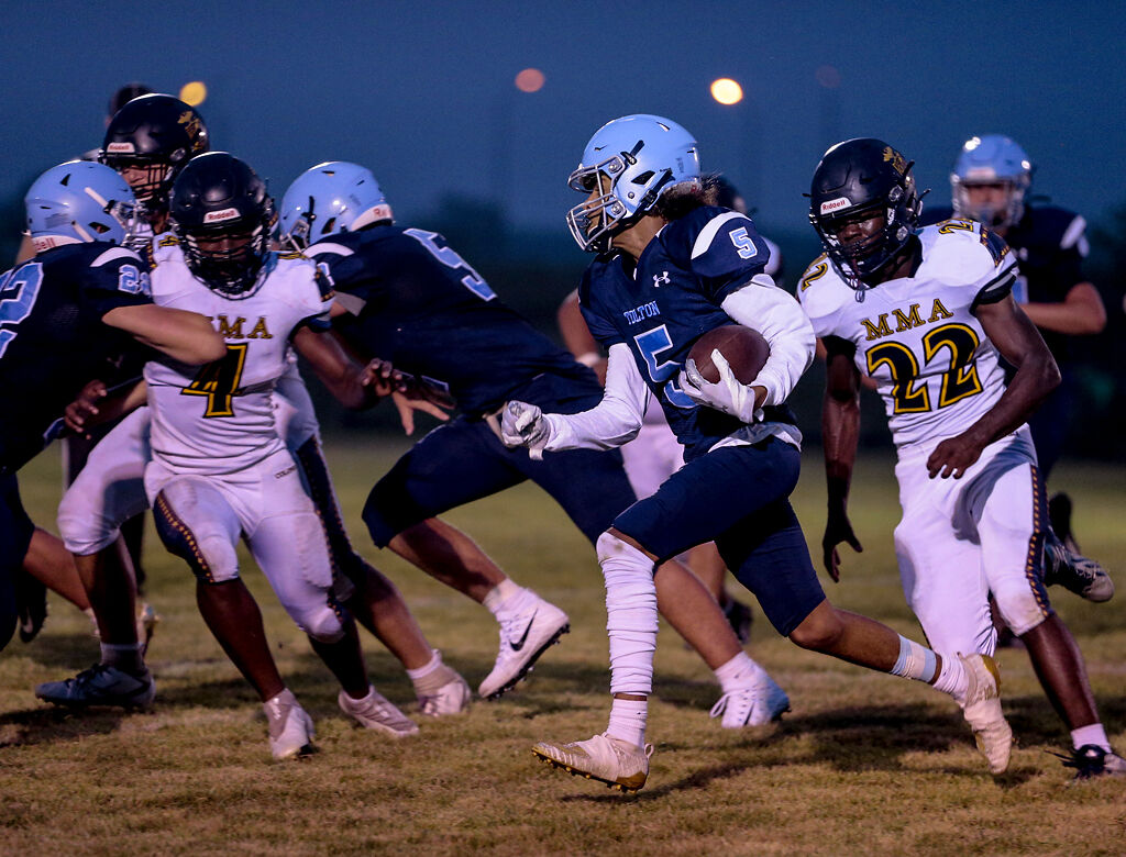 Tolton players attempt to protect Tolton junior Julian McKoy
